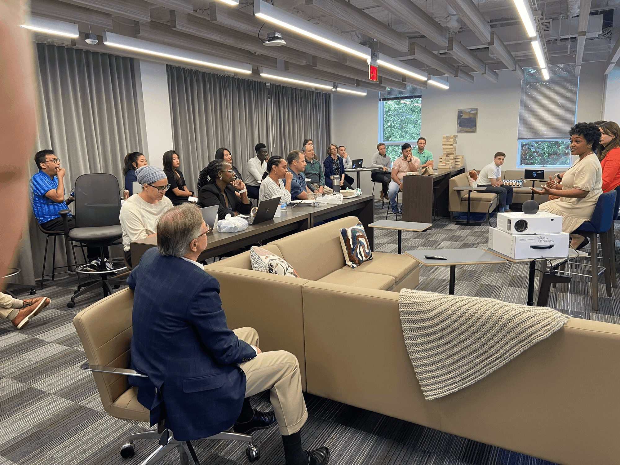 Rashan Thompson leading an interactive workshop session with an engaged group in a modern workspace
